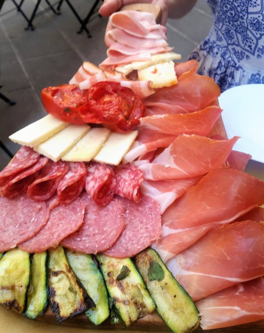 Salumi charcuterie board showcasing fried courgettes, salami and Spoleto Prosciutto in Italy. 