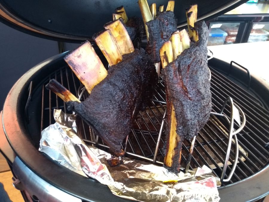 Deliciously charred ribs on a smoker grill, promising a smoky feast with essential Tools & Equipment for Grilling Meat.