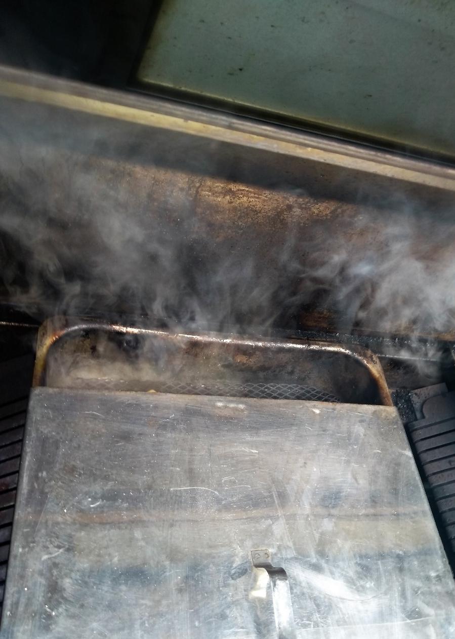 A smoky scene as vapor rises from a heated metal container, suggesting a process of cooking or heating is underway.