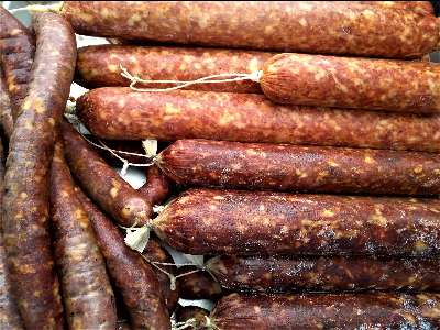 An assortment of fresh, rustic sausages on display.