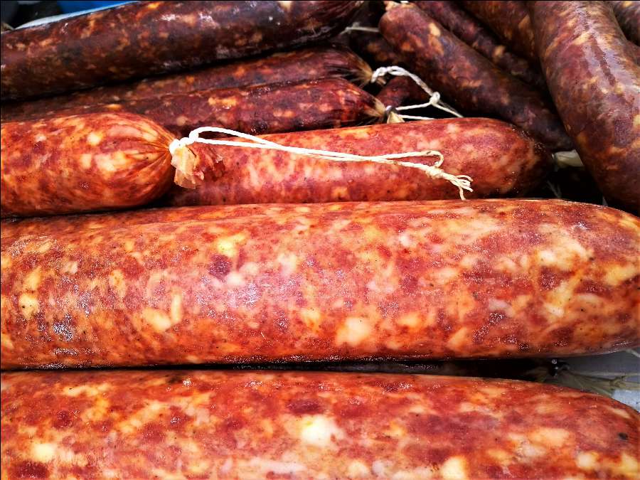 An assortment of freshly made sausages on display, showcasing their rich colors and textures.