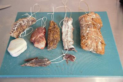 Various cured meats made with different styles on a chopping board.
