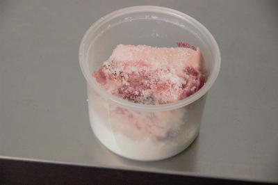 A plastic container with frozen contents covered in frost.