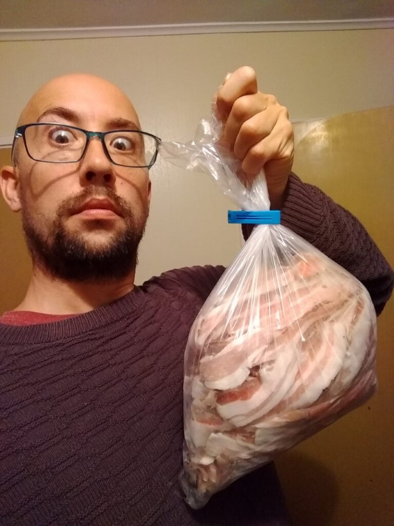 Man and a bag of frozen homemade bacon.