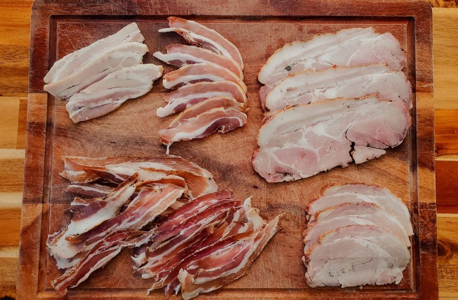 5 different methods of making bacon showcased on a chopping board.