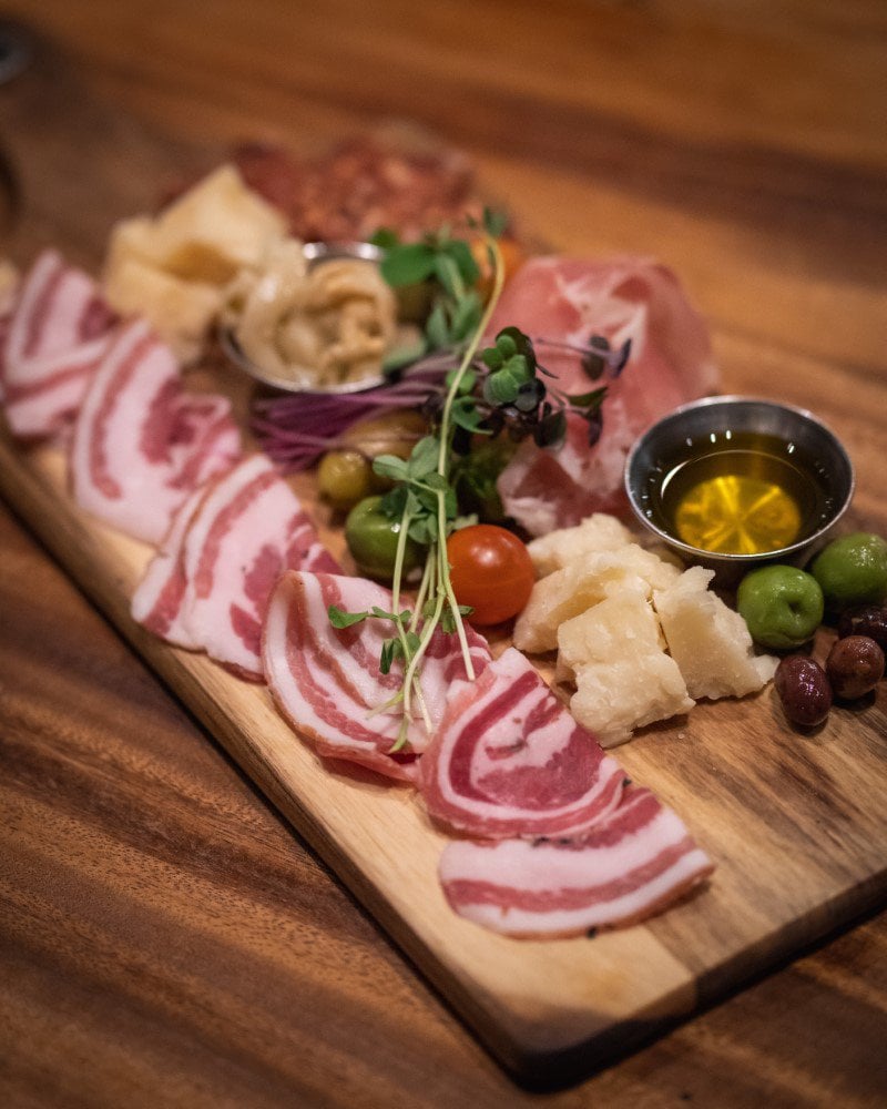 A rustic charcuterie board featuring an assortment of cured meats, cheeses, olives, and accompaniments, beautifully presented on a wooden board with inspiring images & ideas.