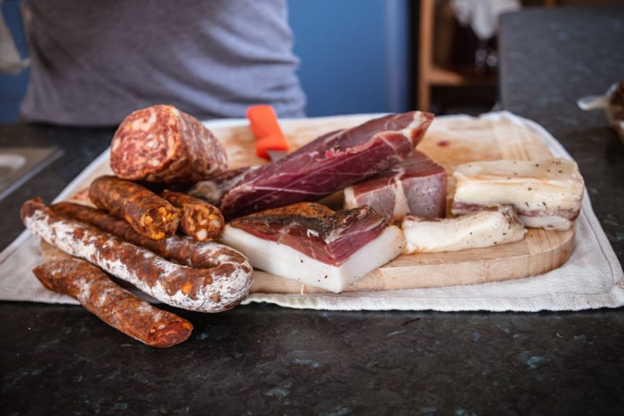 A selection of cured meats and sausages artfully arranged on a wooden cutting board, ready for a gourmet charcuterie experience.