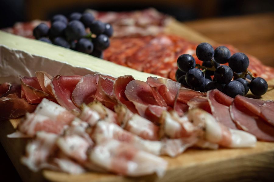 A delectable charcuterie board featuring an assortment of cured meats and fresh grapes, invitingly arranged on a wooden platter.