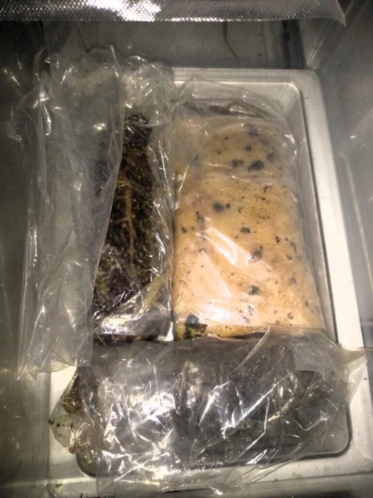 Meat in bags, curing inside a fridge drawer.