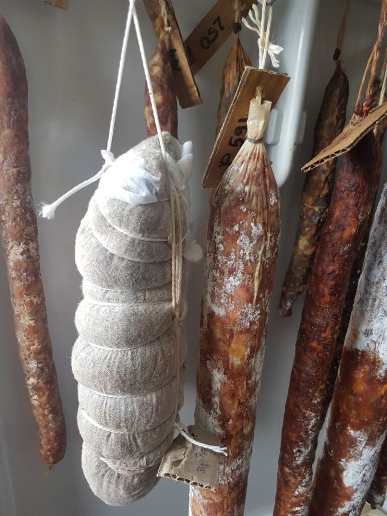 Cured Meat hanging inside a fridge.