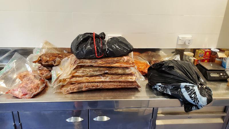 Bags of salt cured meat on a bench.